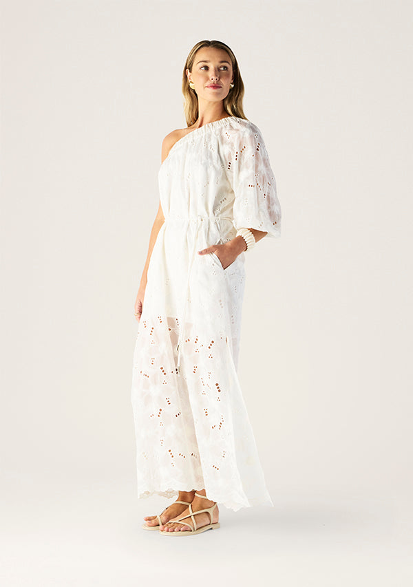Woman wearing a white dress with floral embroidery on a white background