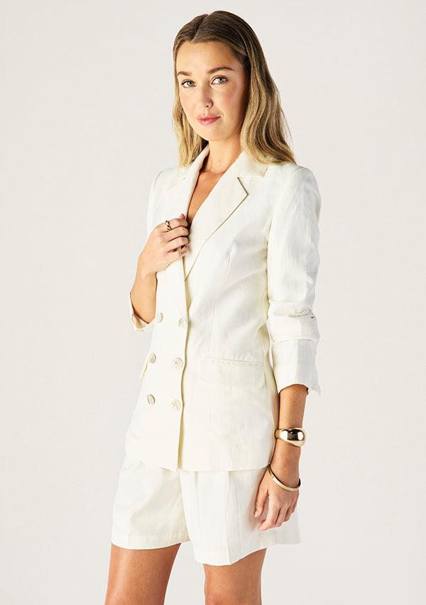 Woman wearing a white suit with a plain background