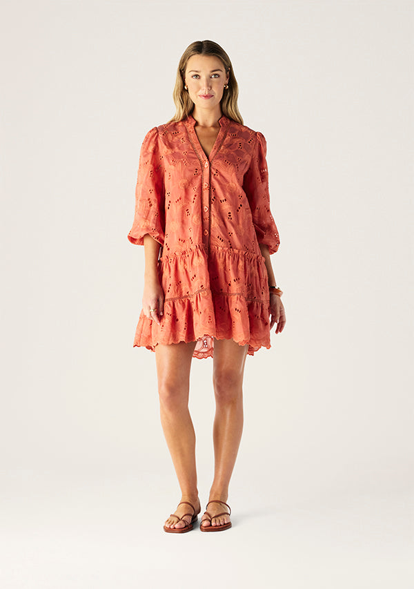 Woman wearing a coral dress on a white background